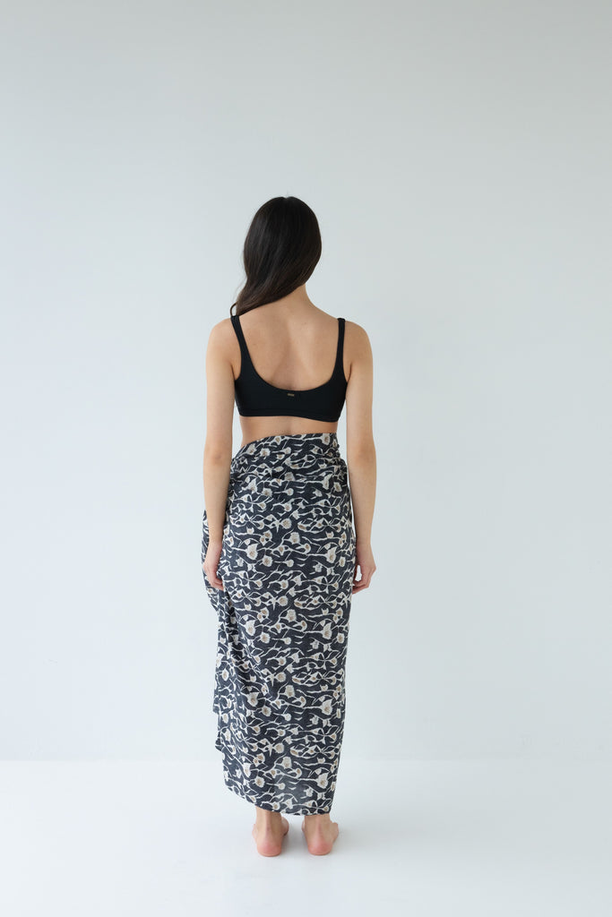 Woman wearing a black top and Sophie Sarong in the floral Coast print