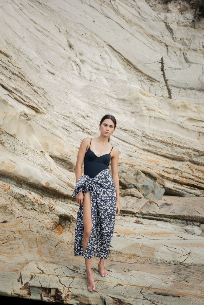 Woman wearing a black top and Sophie Sarong in the floral Coast print