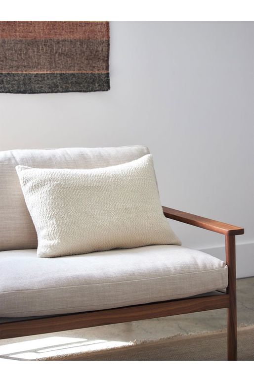 Rectangular Boucle Natural Cushion 80% Wool/20% Cotton. Shown sitting on a  chair.