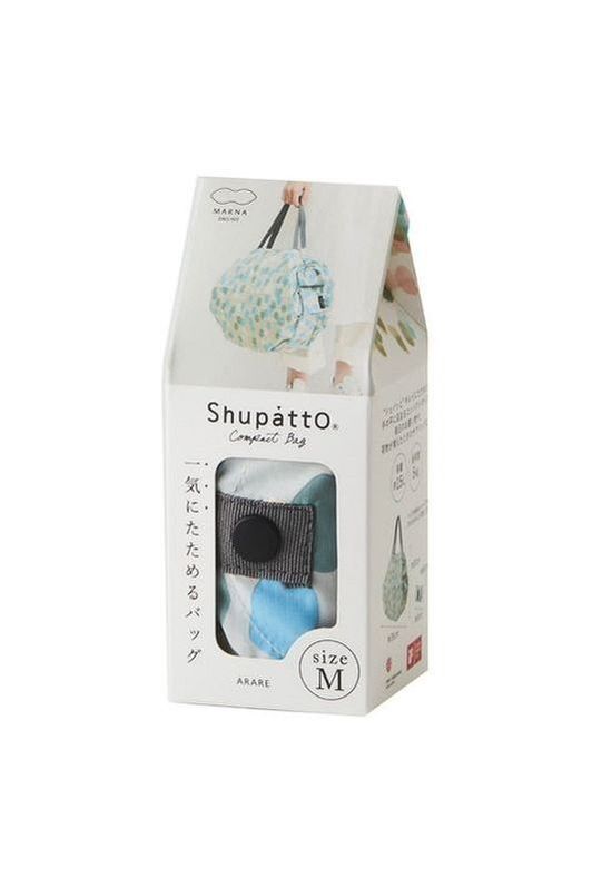 The Shupatto Compact Medium Reusable Shopping Bag in Arare features a hailstone pattern in light blue, sage green, cream, and grey handles. Bag shown inside its packaging display box.