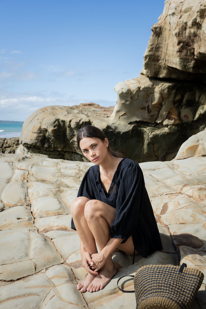 Woman wearing a black outfit on a white background. Sophie Tie Top in black Check.
