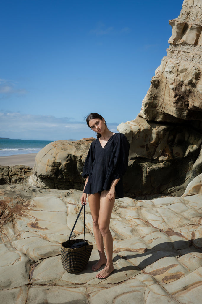 Woman wearing a black outfit on a white background. Sophie Tie Top in black Check.