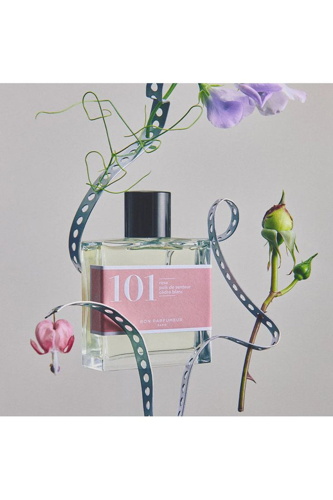 Bon Parfumuer Bottle of Eau de Parfum 101 artistically displayed amongst some of its ingredients Sweet Peas and Roses